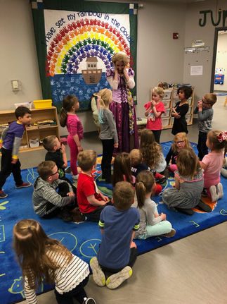 Rapunzel surrounded by excited kids during a classroom visit