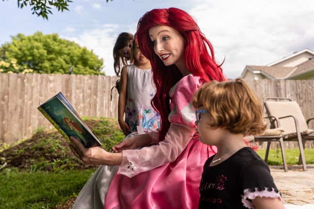 Little Mermaid reading to children outdoors, close-up