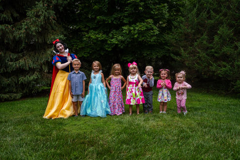 Sleeping Beauty lined up outdoors with seven children in height order